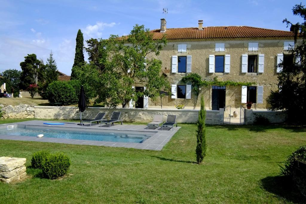 een huis met een zwembad voor een tuin bij Maison Breton in Biran