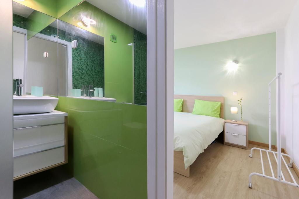 Baño verde con cama y lavabo en Relaxing Guesthouse - Sónias Houses en Lisboa