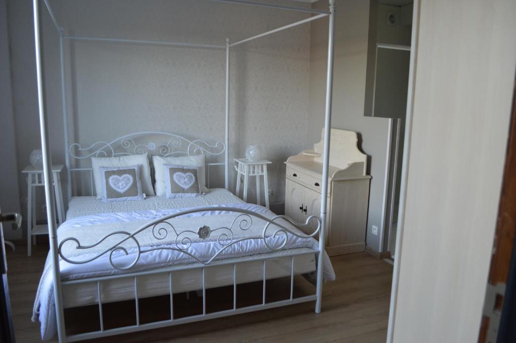 a bedroom with a white canopy bed with pillows at Gite Terre de ciel in Ferrières