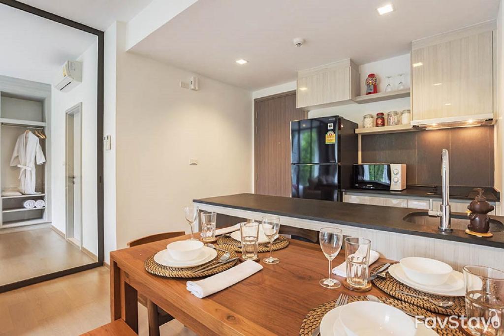 a kitchen with a wooden table with plates and wine glasses at The Valley Moutain Khaoyai in Phayayen