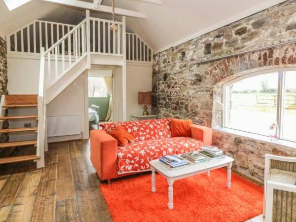 a living room with a couch and a table at The Cowhouse in Carrick-on-Suir