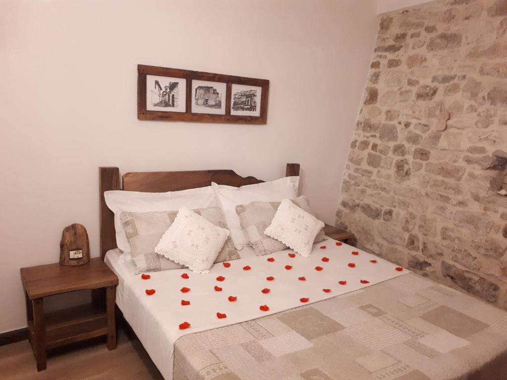 Un dormitorio con una cama con corazones rojos. en Hotel Omer en Berat