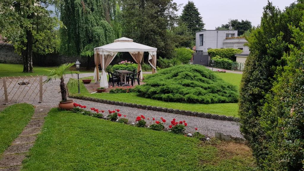a garden with a gazebo and red flowers at Villa del Cigno in Lecco