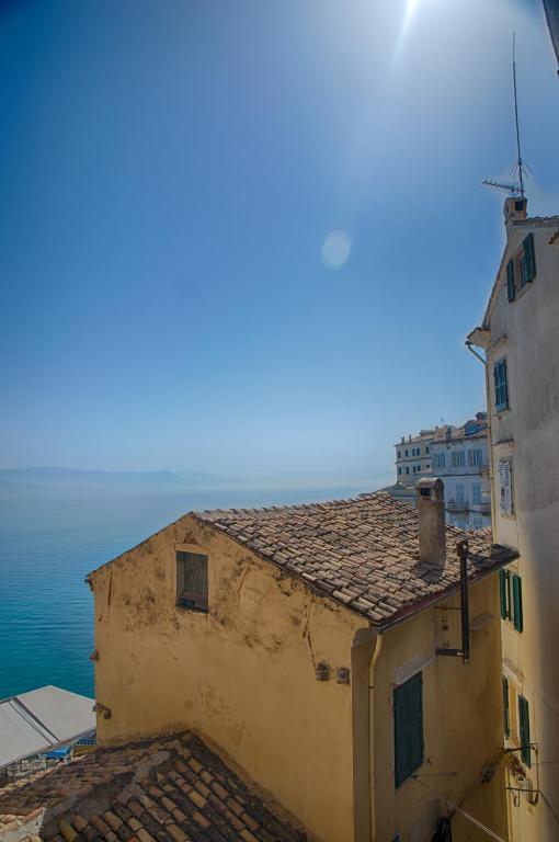 a view of a building with the ocean in the background at Serene Sea View Apartment in Corfu Old Town in Corfu