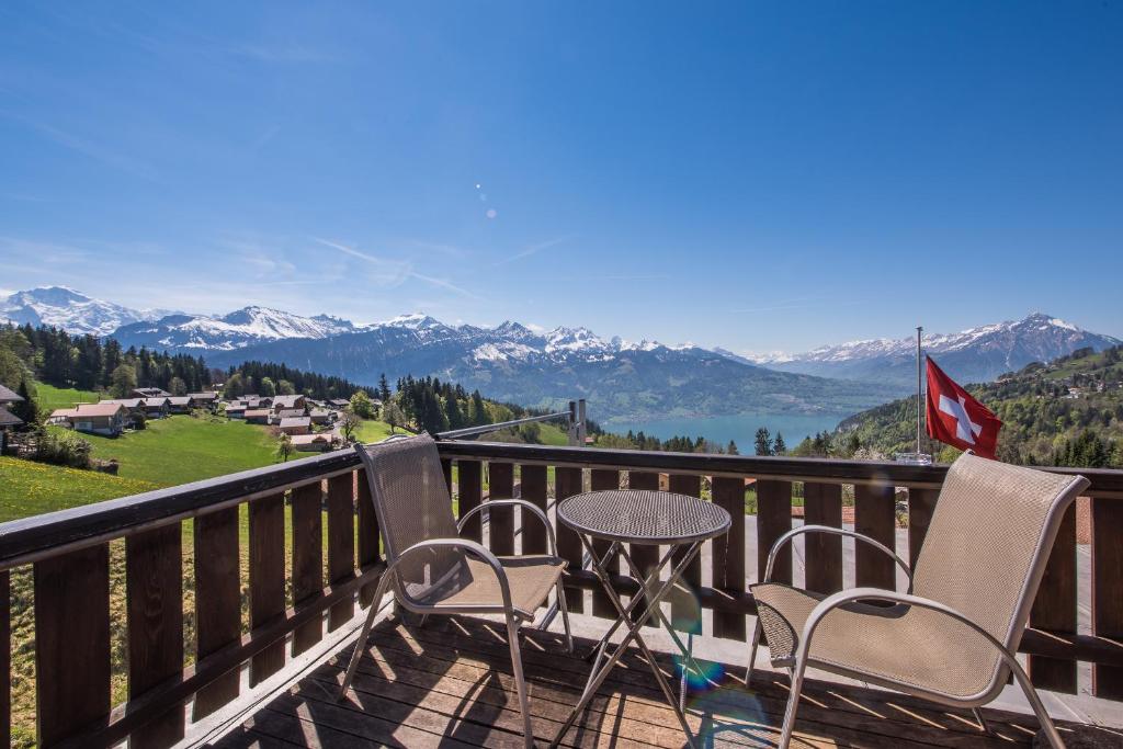 a table and chairs on a balcony with a view at Hotel Fassbind Beausite in Beatenberg
