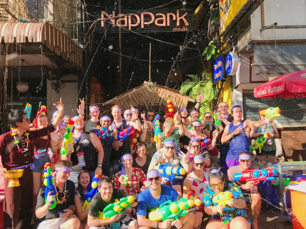 Un groupe important de personnes se pose une photo dans l'établissement Nappark Hostel @Khao San, à Bangkok