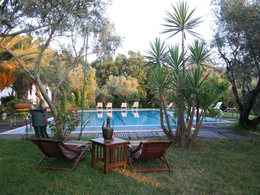 due sedie e un tavolo di fronte alla piscina di Cozy Holiday Home in Calabria with Garden a Maida