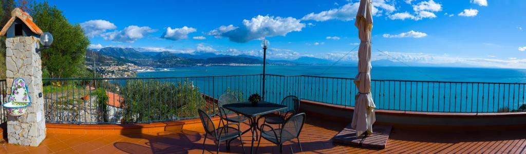 a balcony with a table and chairs and a view of the water at Il Glicine in Cetara