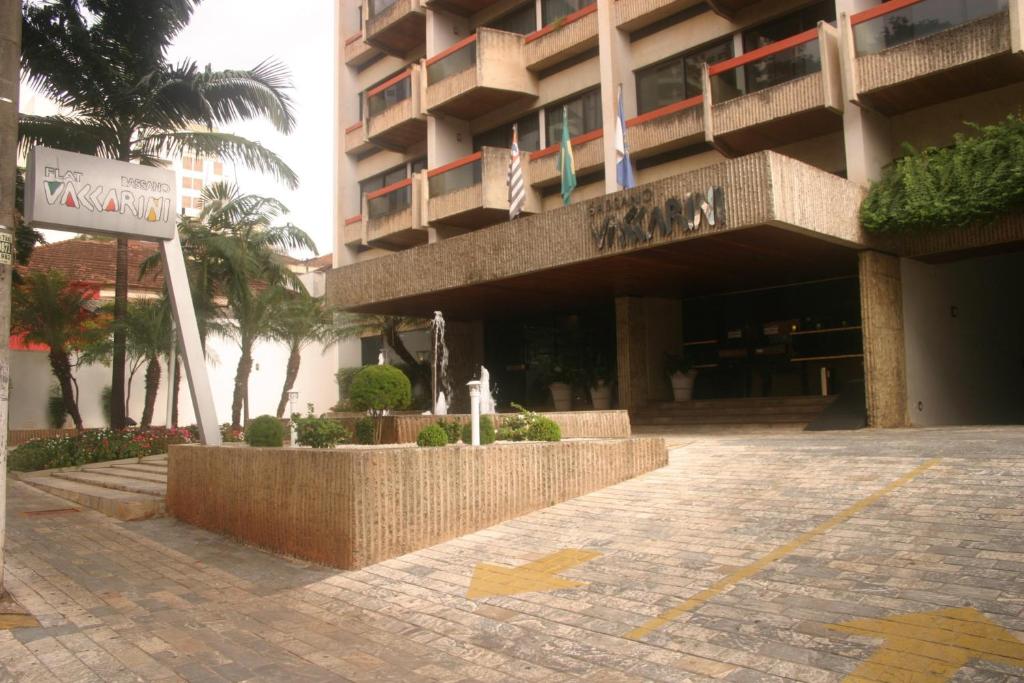 un edificio con una señal delante de él en Hotel Flat Bassano Vaccarini, en Ribeirão Preto