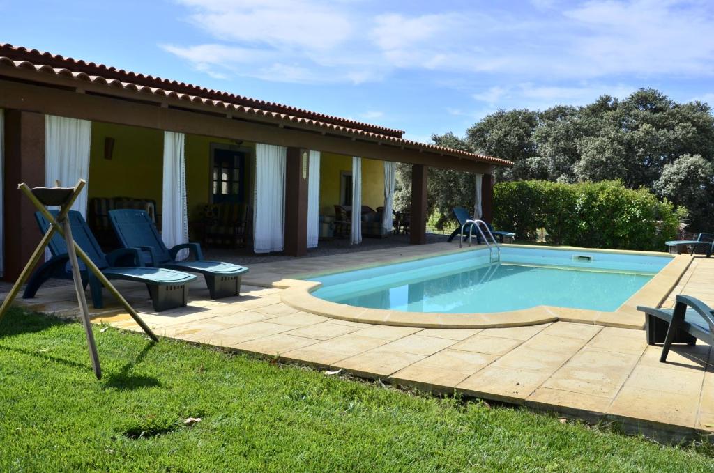 - une piscine avec une terrasse et des chaises à côté d'une maison dans l'établissement Quinta do Chao D'Ordem, à Vila Nova de Foz Coa