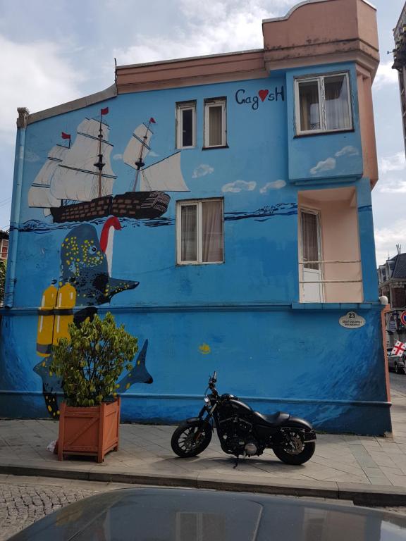 una moto parcheggiata di fronte a un edificio blu di Apartment Giorgi Mazniasvhili a Batumi