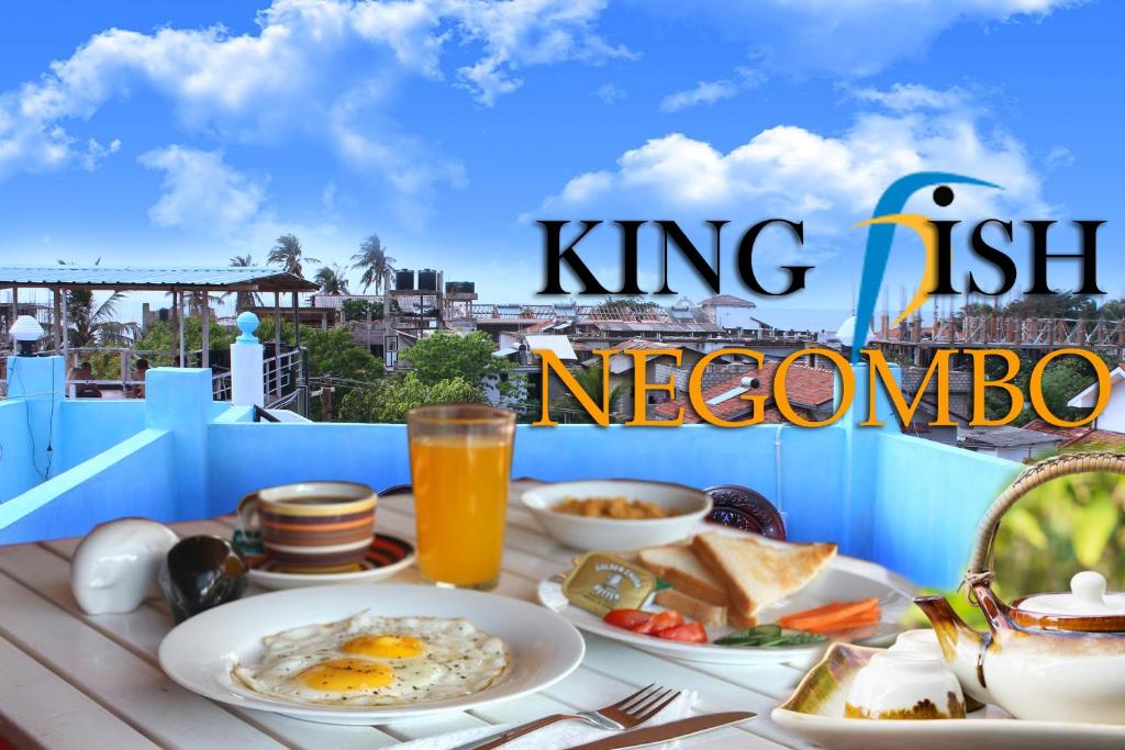 King Fish Guest House في نيجومبو: طاولة إفطار مع البيض والخبز المحمص على شرفة