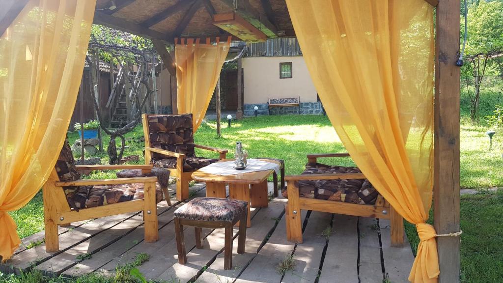 a wooden table and chairs under a gazebo at Lion Cottage in Chuprene