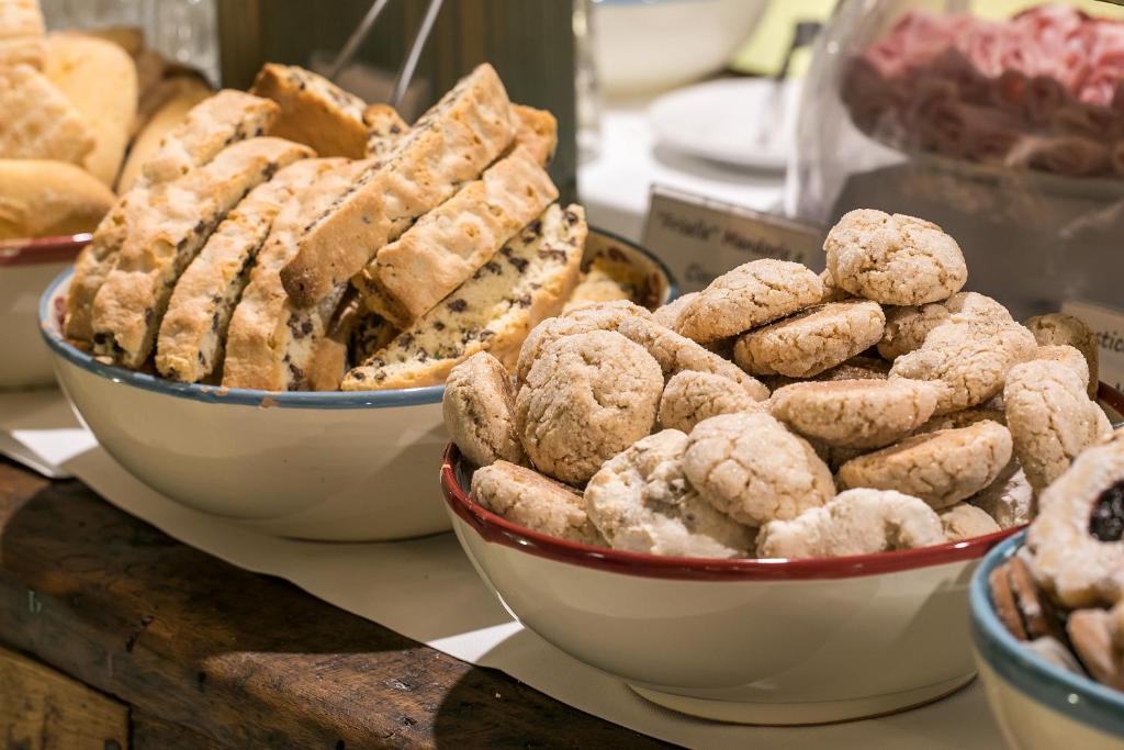 two bowls of cookies and other pastries on a counter at Locanda Di San Martino Hotel & Thermae Romanae in Matera