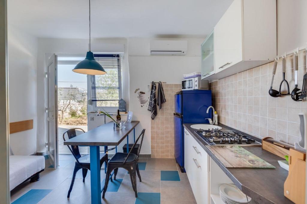 a kitchen with a table and a blue refrigerator at Apartment Marija in Petrcane