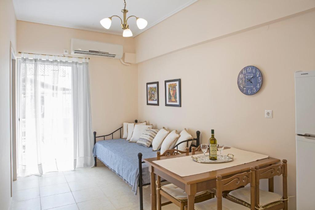 a bedroom with a bed and a table with a dining room at Remezzo Apartments in Akrogiali