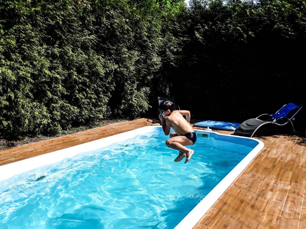 a man is jumping into a swimming pool at Apartamenty Pan Tadeusz Ustroń in Ustroń