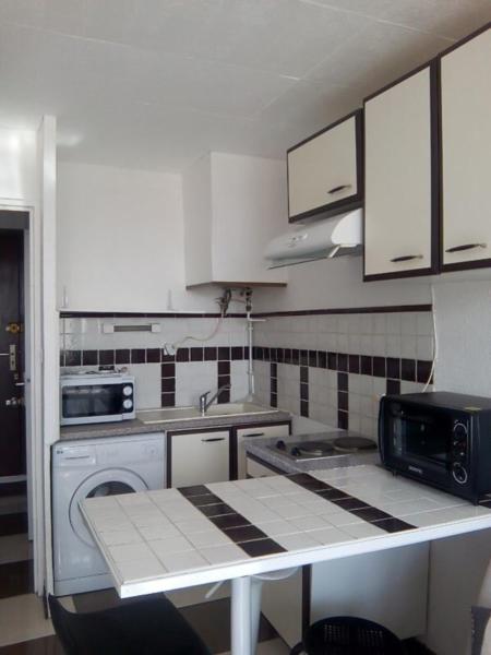 une petite cuisine avec un évier et un micro-ondes dans l'établissement 6 Rue du Labech, au Cap d'Agde