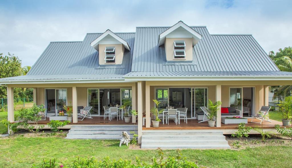 a house with a blue roof at Villas Coco Beach Praslin in Anse Kerlan