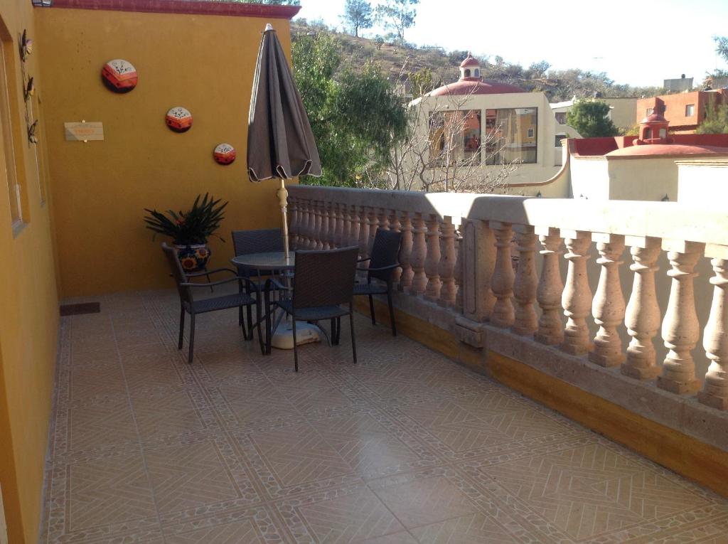 a balcony with a table and an umbrella at Casona de Cantera in Guanajuato