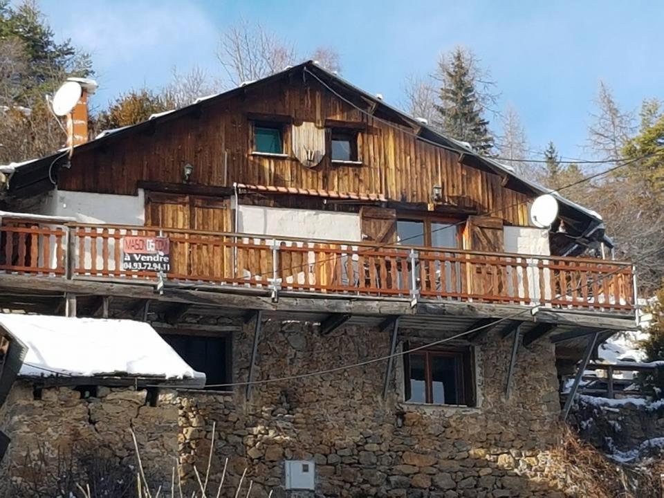 drewniany dom z balkonem na górze w obiekcie Sur Un Petit Nuage w mieście Roubion