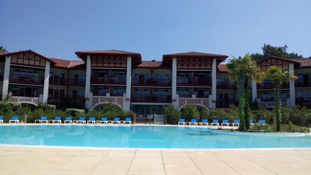 un gran edificio con una piscina frente a él en Appartement dans résidence de vacances en Biscarrosse