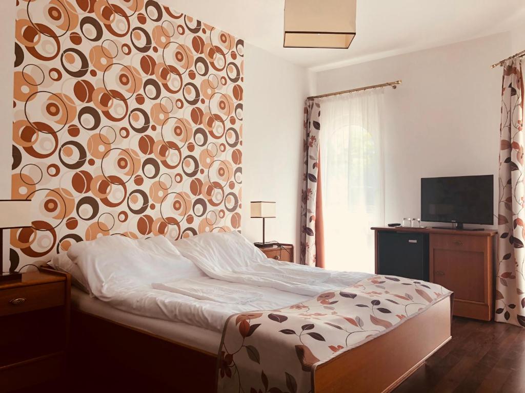 a bedroom with a bed and a large wall with at Zöldtető Panzió in Balatonfüred