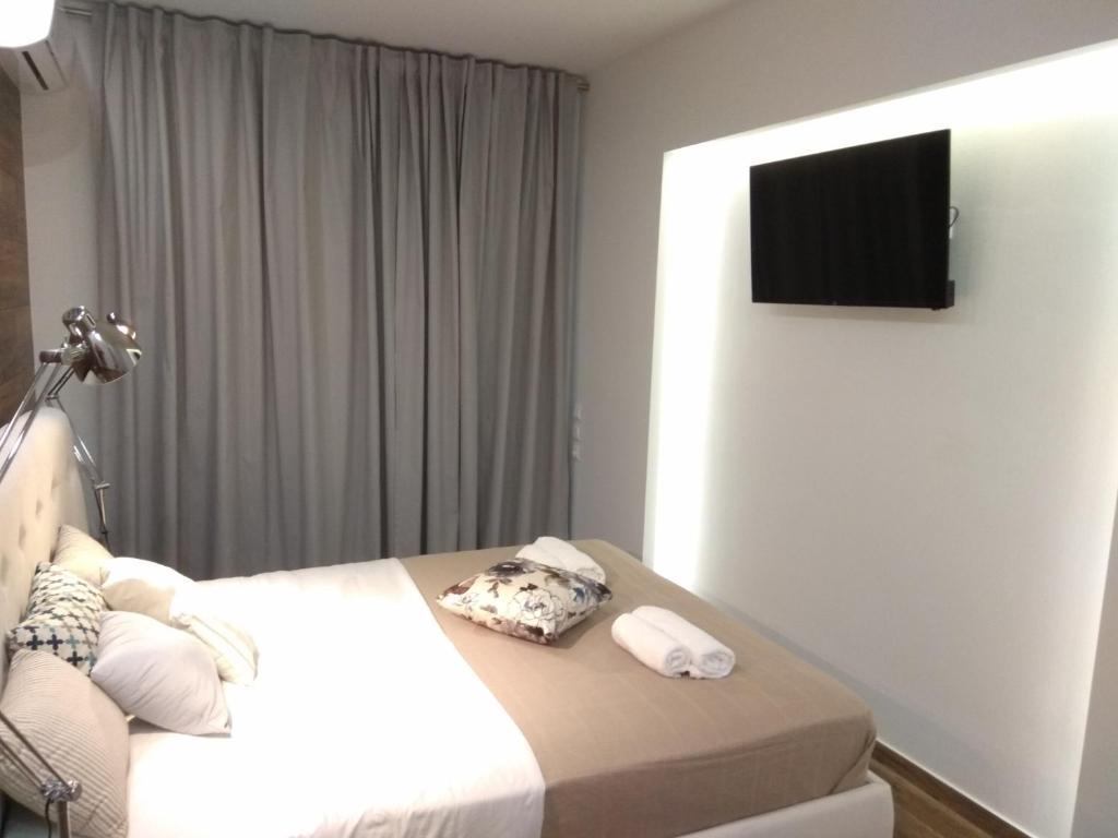 a hotel room with a bed and a flat screen tv at Limonchello in Kalamata