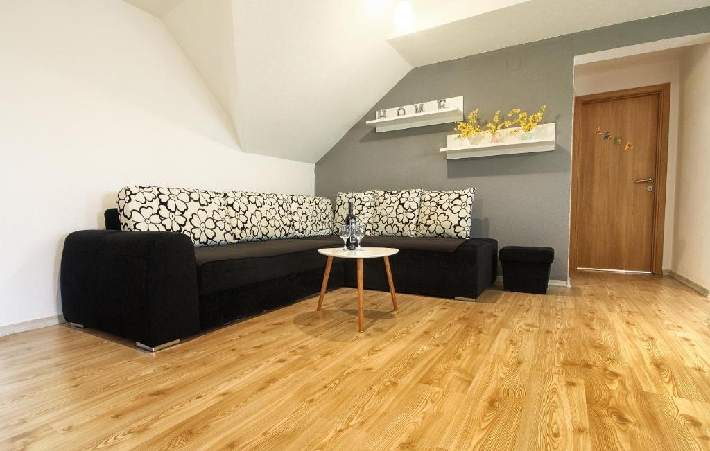 a living room with a black couch and a table at Apartment Lana in Rakovica