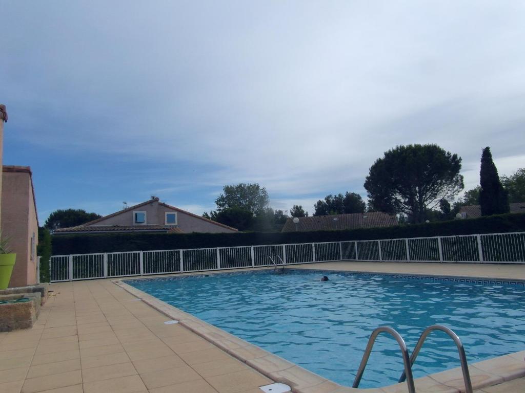 une grande piscine entourée d'une clôture. dans l'établissement Résidence Hameau du Soleil, à Valras-Plage
