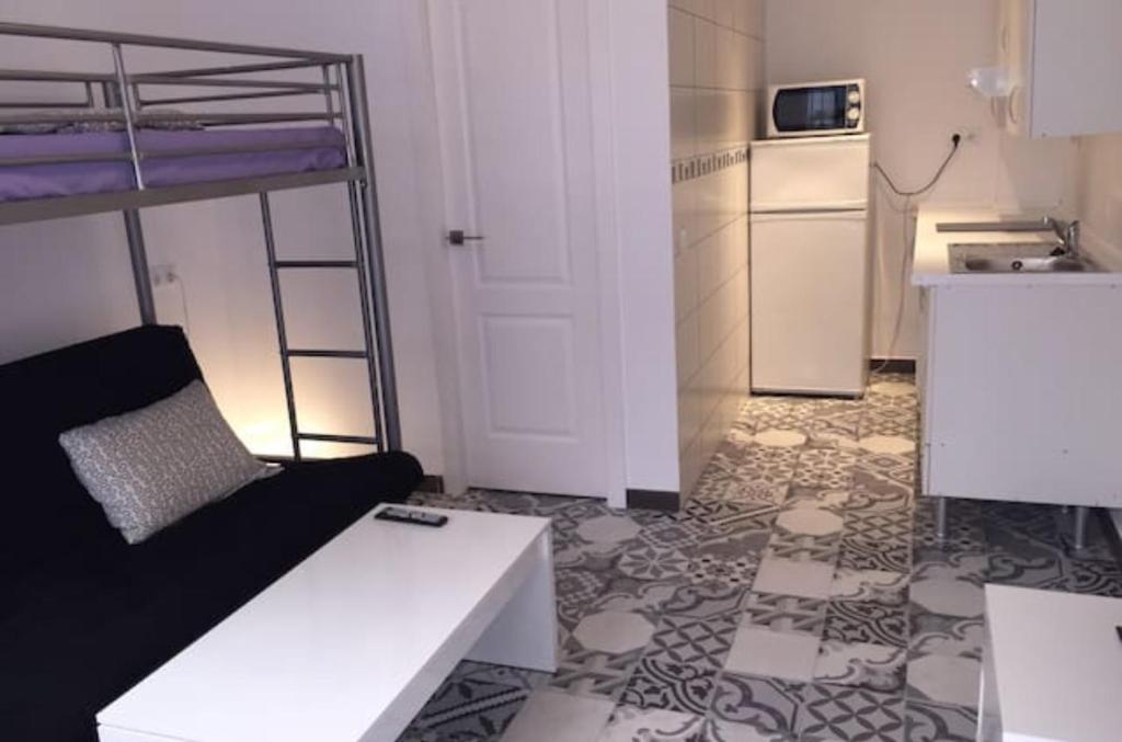 トレモリノスにあるLa Nogalera Squareのリビングルーム(白いソファ付)、キッチンが備わります。