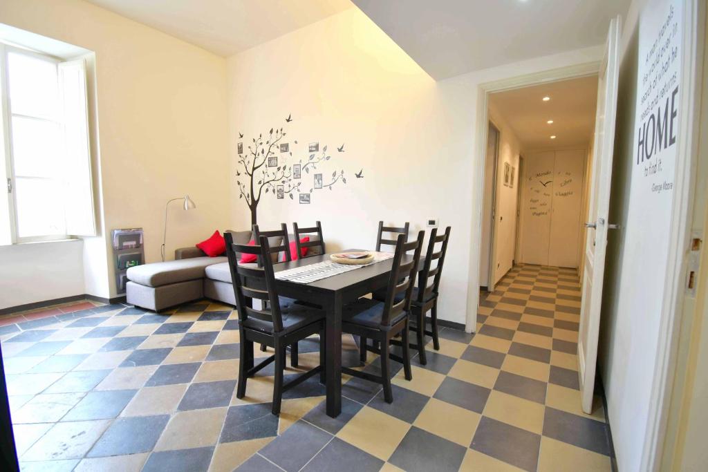 a dining room with a table and chairs on a checkered floor at Le Rondini a Roma in Rome