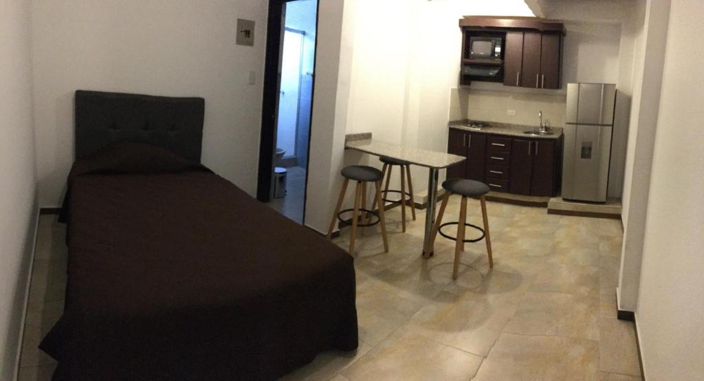 a small room with a bed and a kitchen at Apartaestudio San Nicolas in Popayan