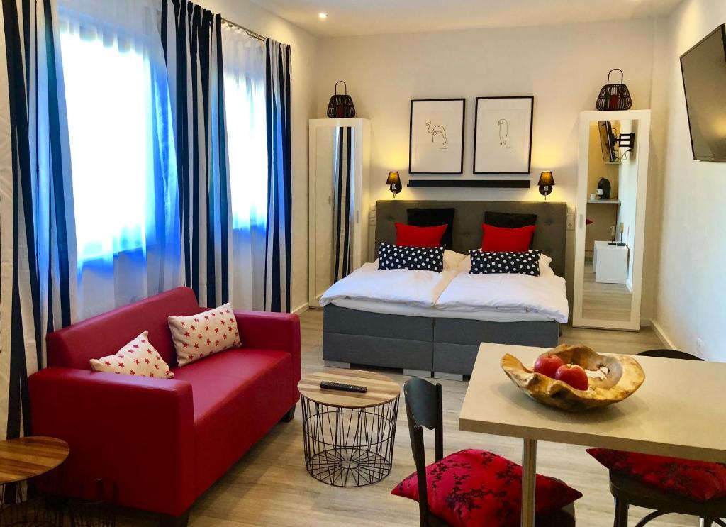 ガイゼンハイムにあるDAS Apartment am Weinbergのベッドルーム1室(ベッド1台、赤い椅子、テーブル付)