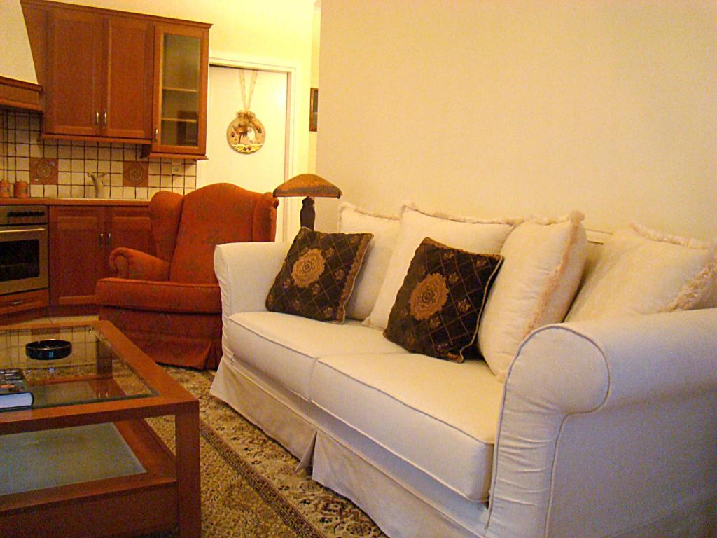 a living room with a white couch and a table at Litochoro Apartments in Litochoro