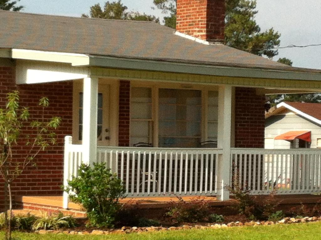 een klein huis met een wit hek bij The Chapman House in Lineville
