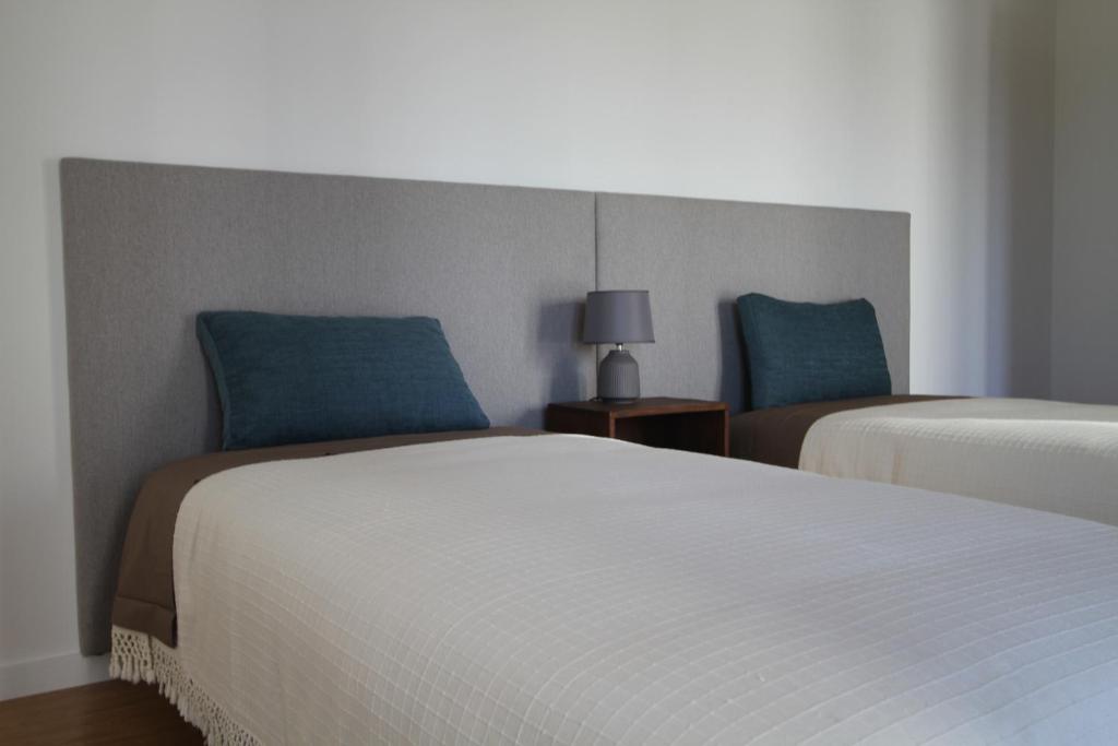 ヴィアナ・ド・カステロにあるA Lenda do Rio do Lethesのホテルルーム ベッド2台 ブルーピロー付