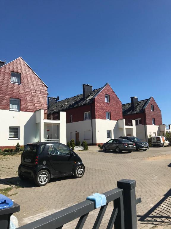 a car parked in a parking lot in front of houses at Baltic Vip Apartamenty Letnie w Rewalu in Rewal