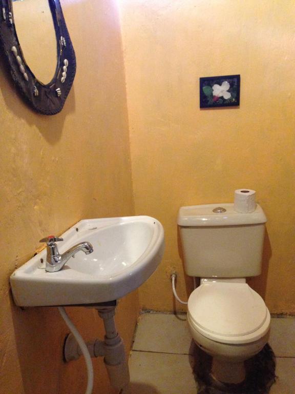 a bathroom with a sink and a toilet and a mirror at Maasai Simba Camp in Amboseli
