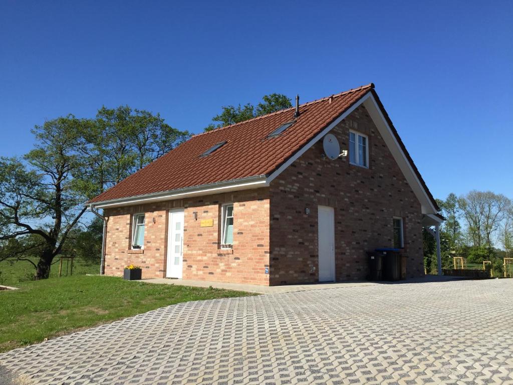 een stenen huis met een rood dak bij Haus Kornfeld in Oberlangen