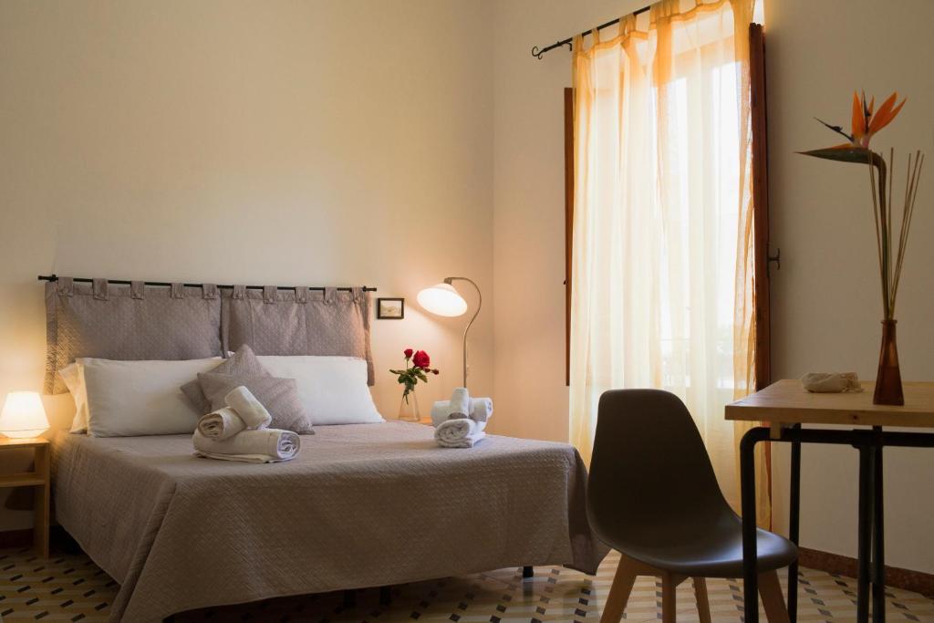 a bedroom with a bed and a chair and a window at Area 12 BB in Trapani