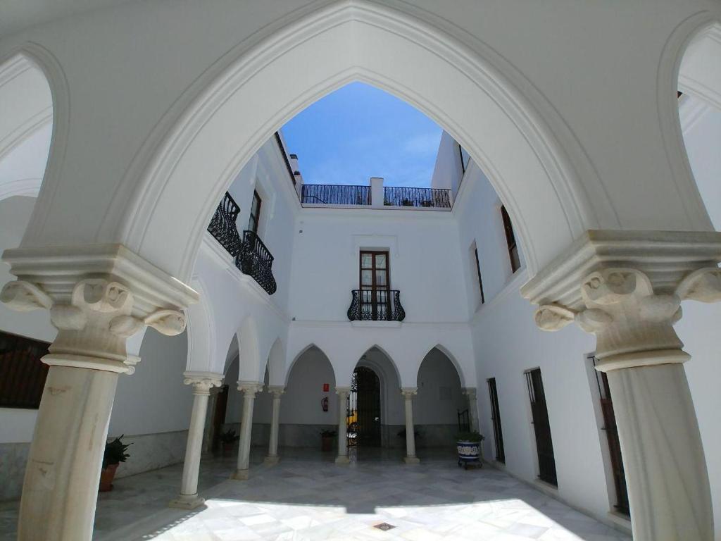 サンルーカル・デ・バラメダにあるDúplex centro, climatizado, garaje, piscina, WIFIの柱の白い建物のアーチ道