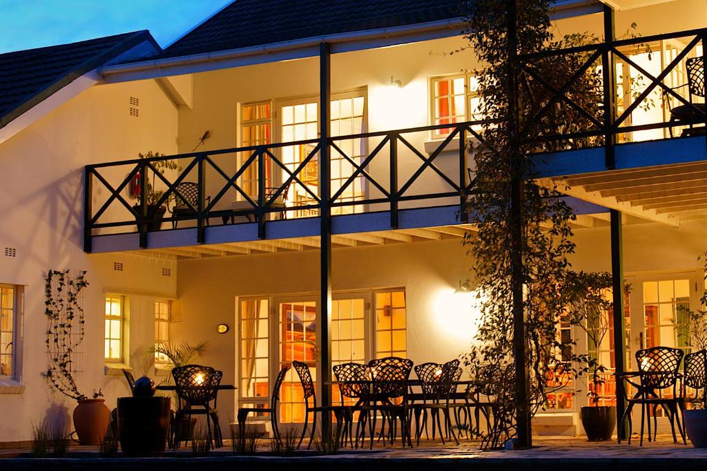 a building with tables and chairs in front of it at Golden Hill Guest House in Somerset West