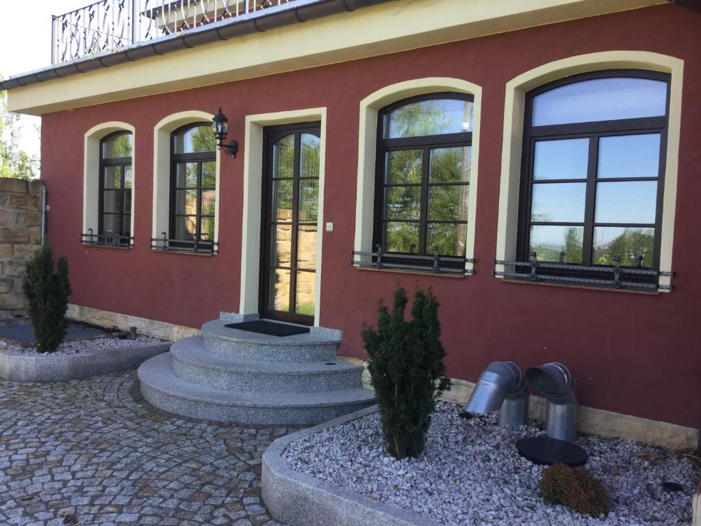 un edificio rojo con ventanas y plantas delante de él en Villa Eddi & Emmi, en Freiberg