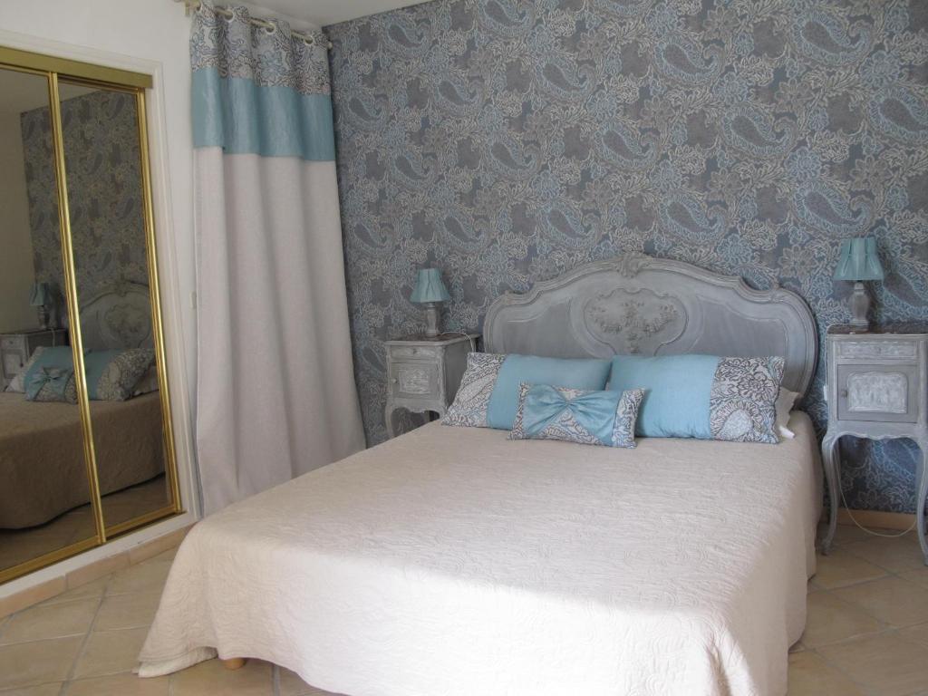 a bedroom with a white bed with blue walls at L&#39;Oustau de Bigatié in Lambesc