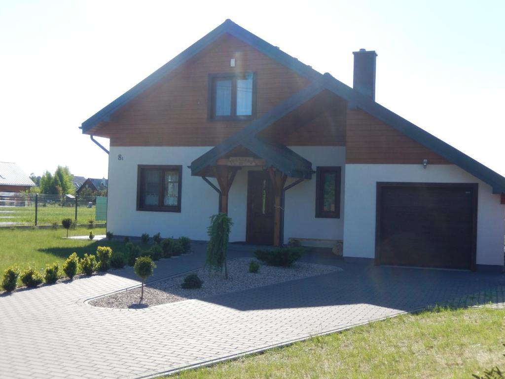 une maison avec un garage en face dans l'établissement Dom wczasowy Tobołowo, à Tobołowo