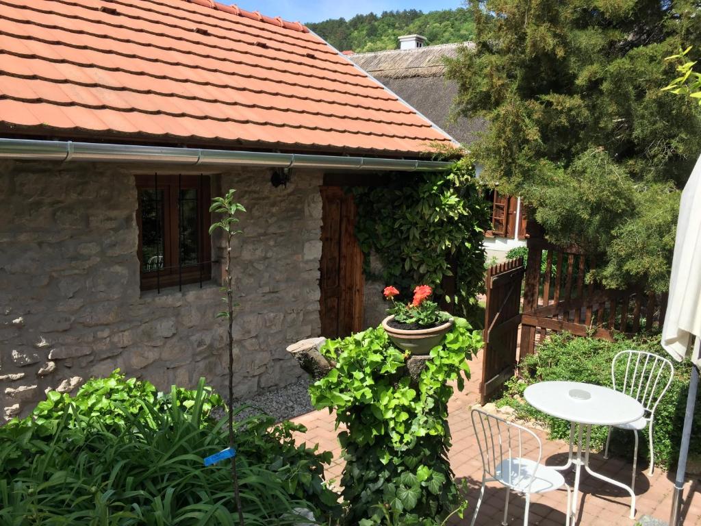 Cette petite maison dispose d'une terrasse avec une table et des chaises. dans l'établissement Arácsi Kisház, à Balatonfüred