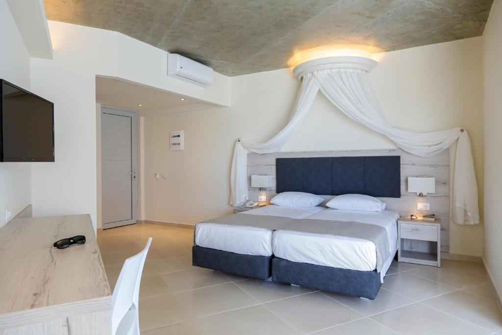 a bedroom with a large bed with a white canopy at Rodos Star Hotel in Afantou