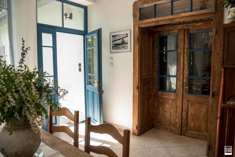 レーヴフュロップにあるLiget Vendégházの木製のドア、テーブルと椅子が備わる客室です。