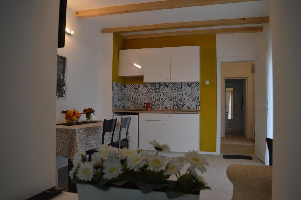 uma cozinha e sala de jantar com uma mesa com flores num quarto em Kućica [kȕtɕitsa] - small house with free parking em Zagreb